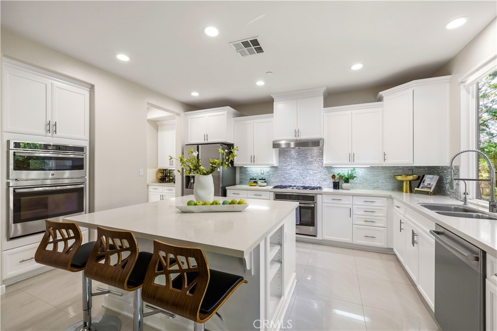 28613 Stonegate Court Valencia, CA 91354 - Photo 10 of 56 a kitchen with a table chairs stove and cabinets