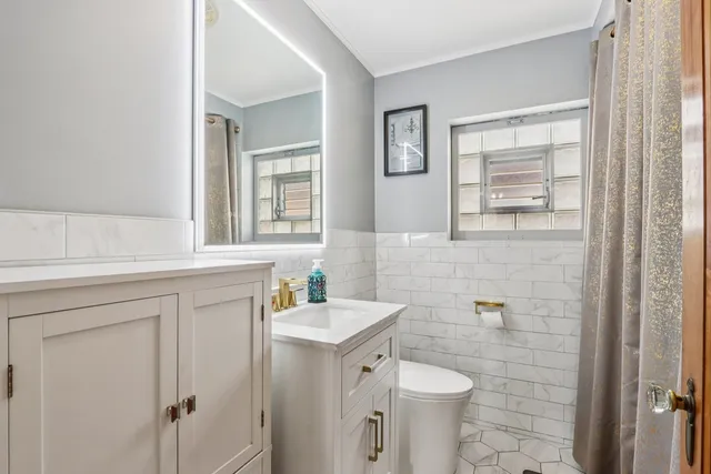 a bathroom with a toilet sink and mirror