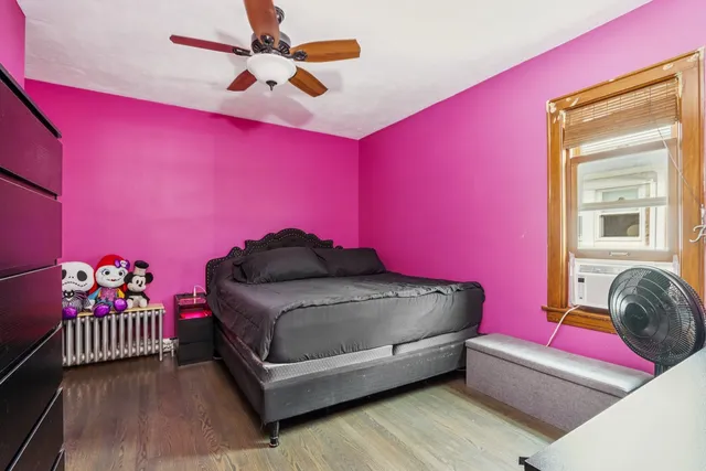 a living room with a bed and a dresser next to a window