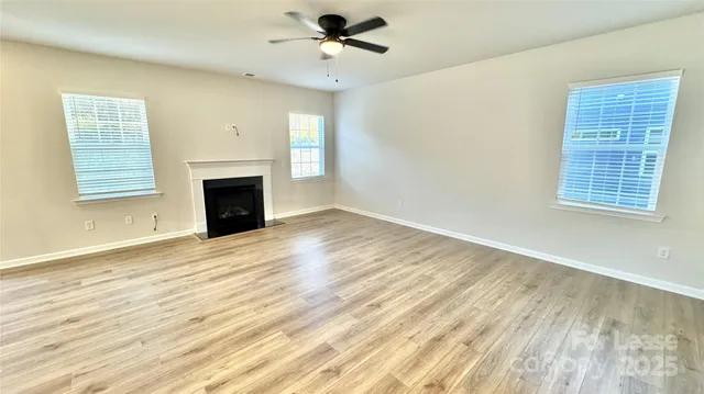 a view of an empty room with a fireplace and a window