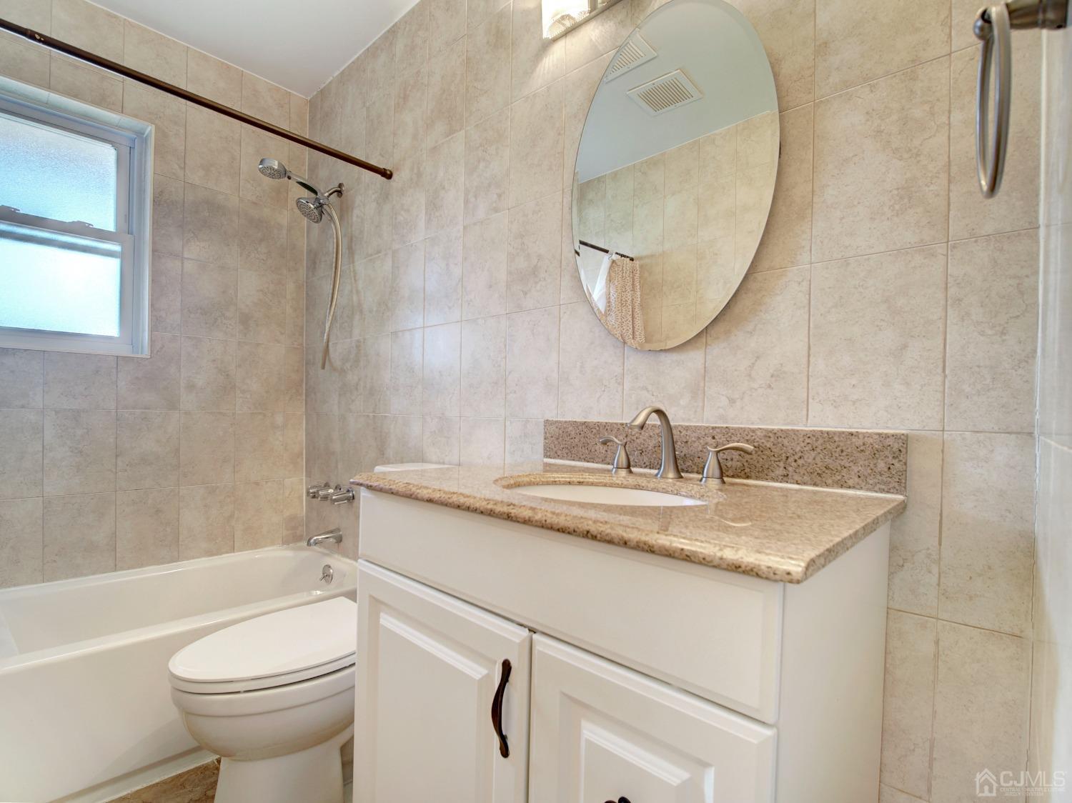 57 Judson Street, Unit 10B Edison, NJ 08837 - Photo 14 of 25 a bathroom with a granite countertop sink toilet and a mirror