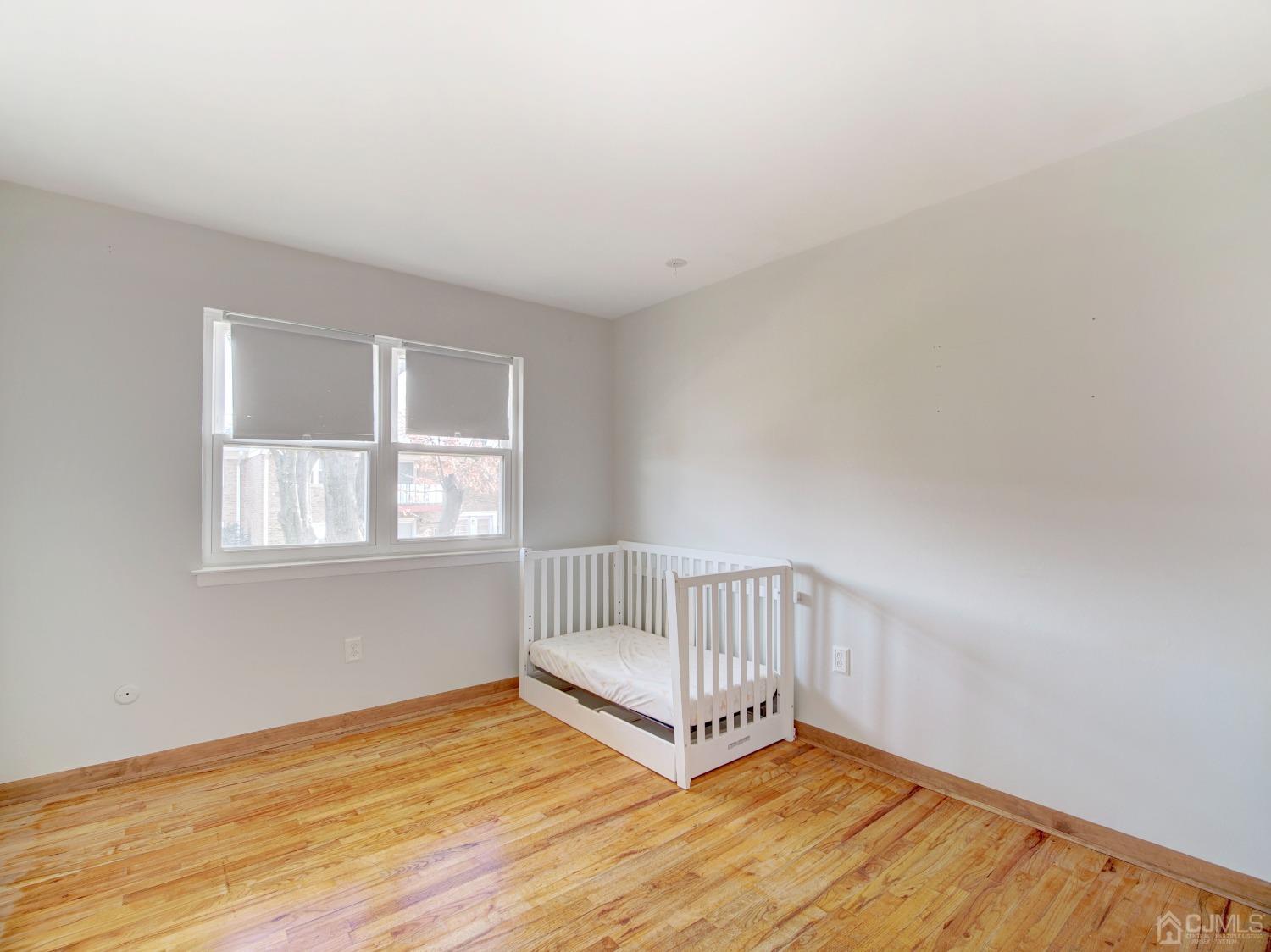 57 Judson Street, Unit 10B Edison, NJ 08837 - Photo 15 of 25 a view of an empty room with wooden floor and a window