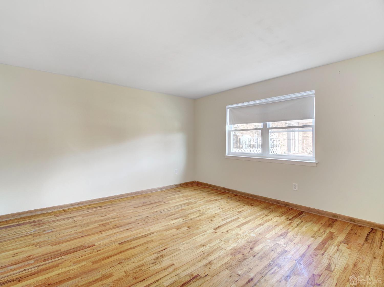 57 Judson Street, Unit 10B Edison, NJ 08837 - Photo 16 of 25 a view of an empty room with wooden floor and a window