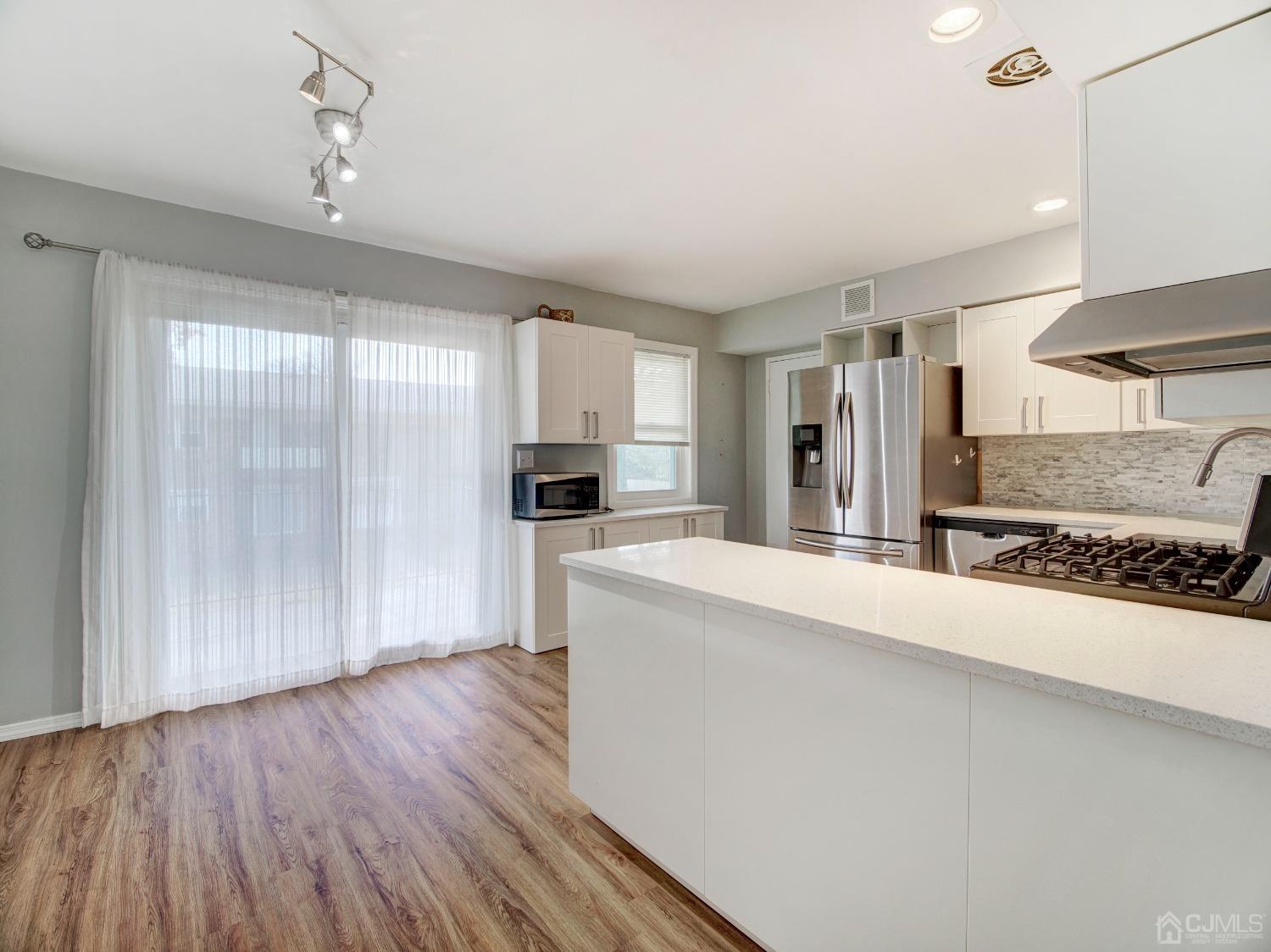 57 Judson Street, Unit 10B Edison, NJ 08837 - Photo 21 of 25 a large kitchen with a wooden floor and stainless steel appliances