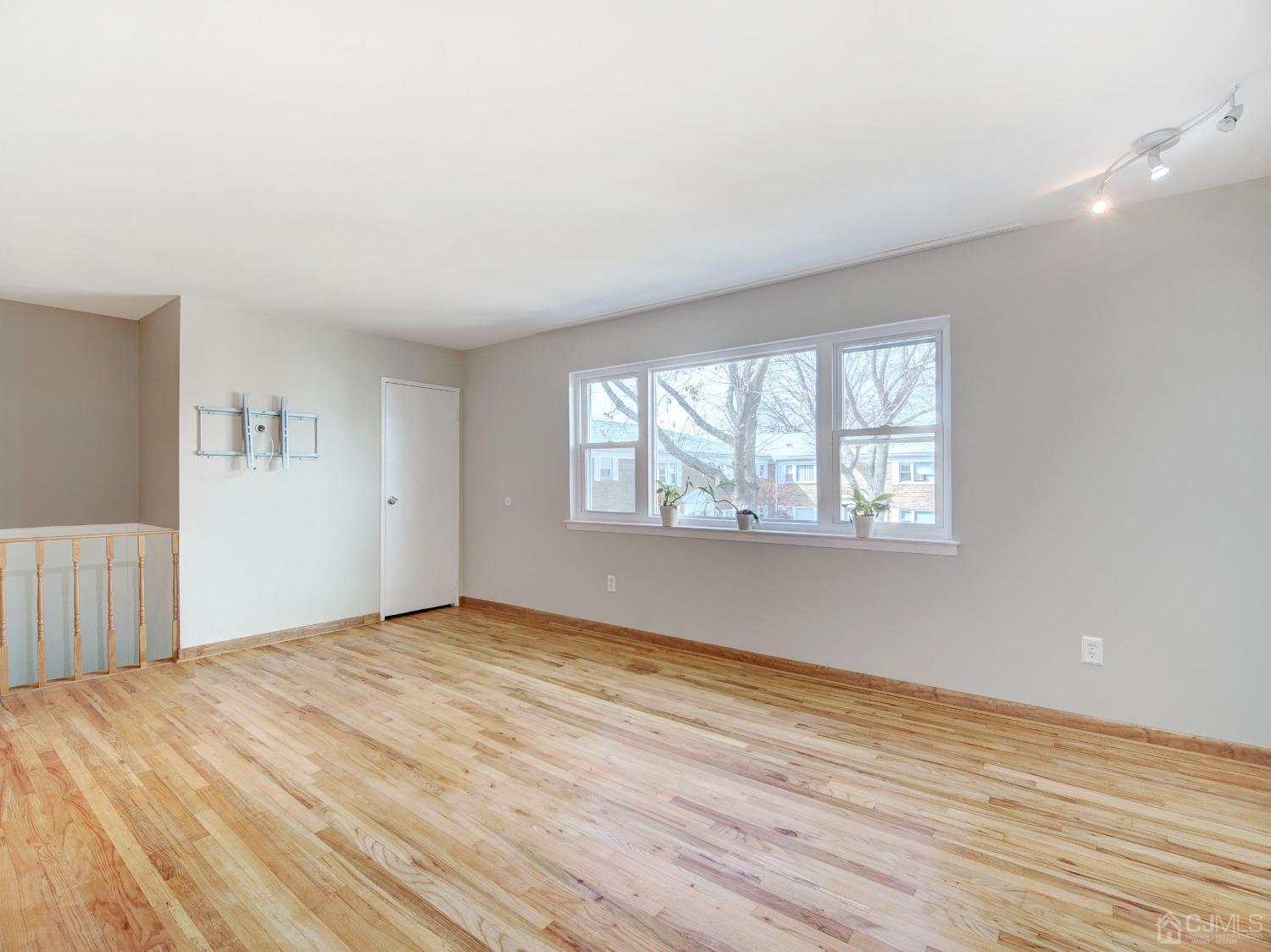 57 Judson Street, Unit 10B Edison, NJ 08837 - Photo 7 of 25 a view of an empty room with wooden floor and a window