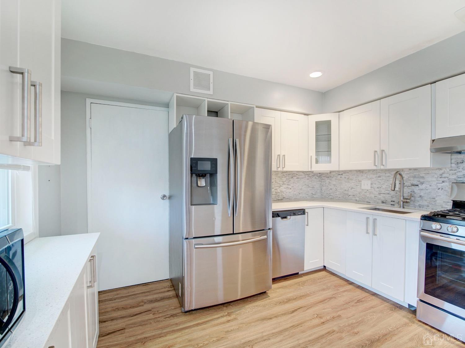 57 Judson Street, Unit 10B Edison, NJ 08837 - Photo 9 of 25 a kitchen with a refrigerator stove and wooden cabinets