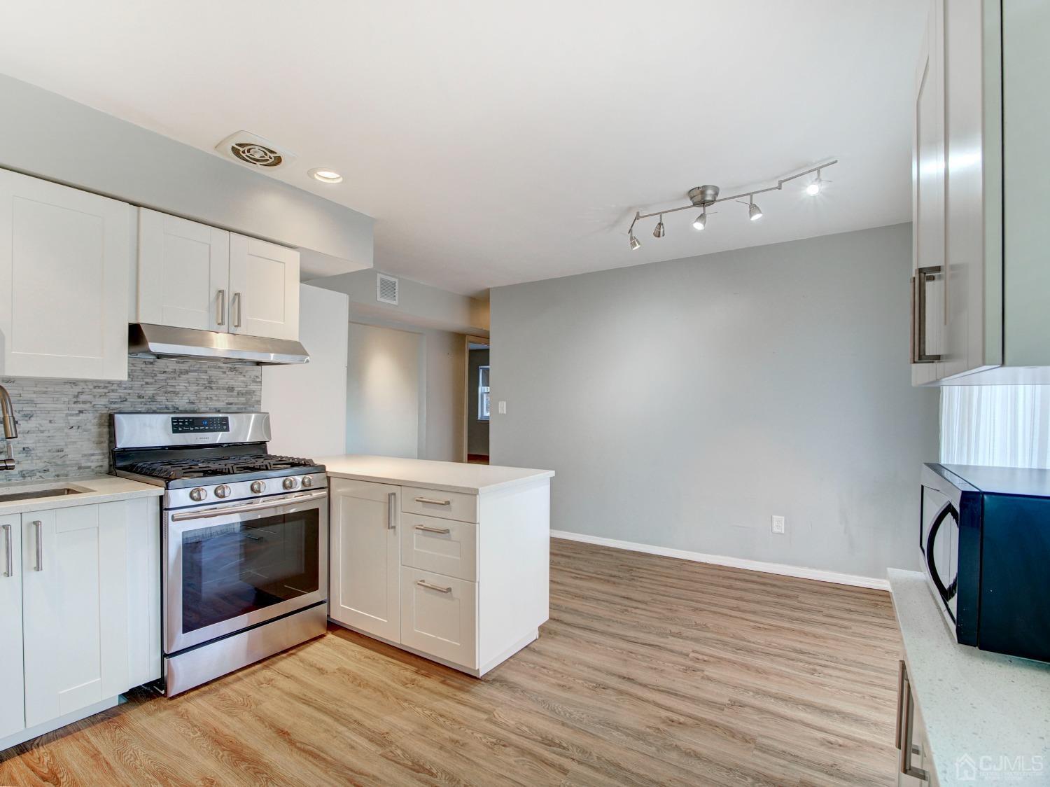 57 Judson Street, Unit 10B Edison, NJ 08837 - Photo 10 of 25 a kitchen with stainless steel appliances a stove top oven a sink and a refrigerator