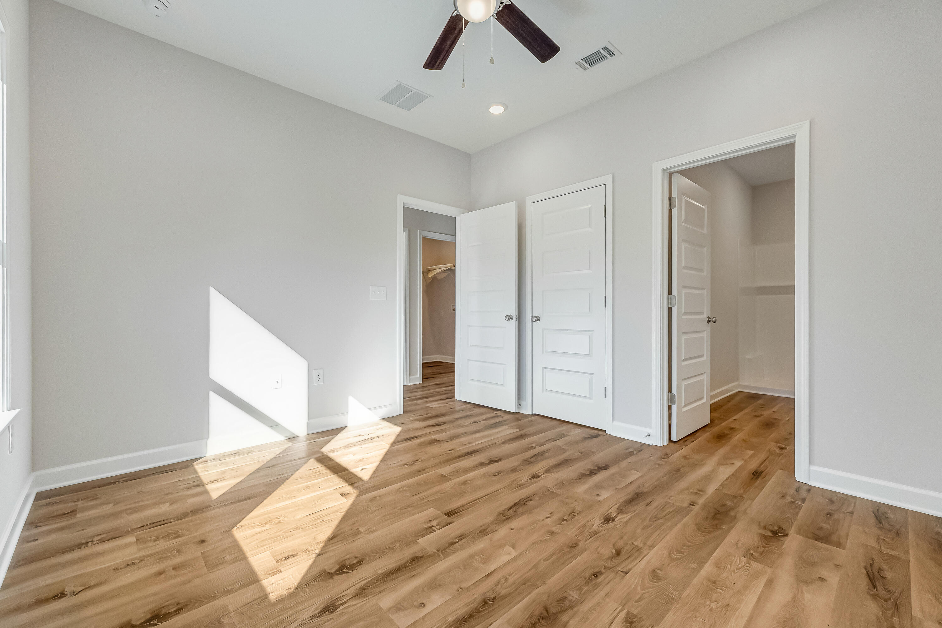 593 Brock Avenue Crestview, FL 32539 - Photo 11 of 19 a view of a livingroom with wooden floor a ceiling fan and kitchen space