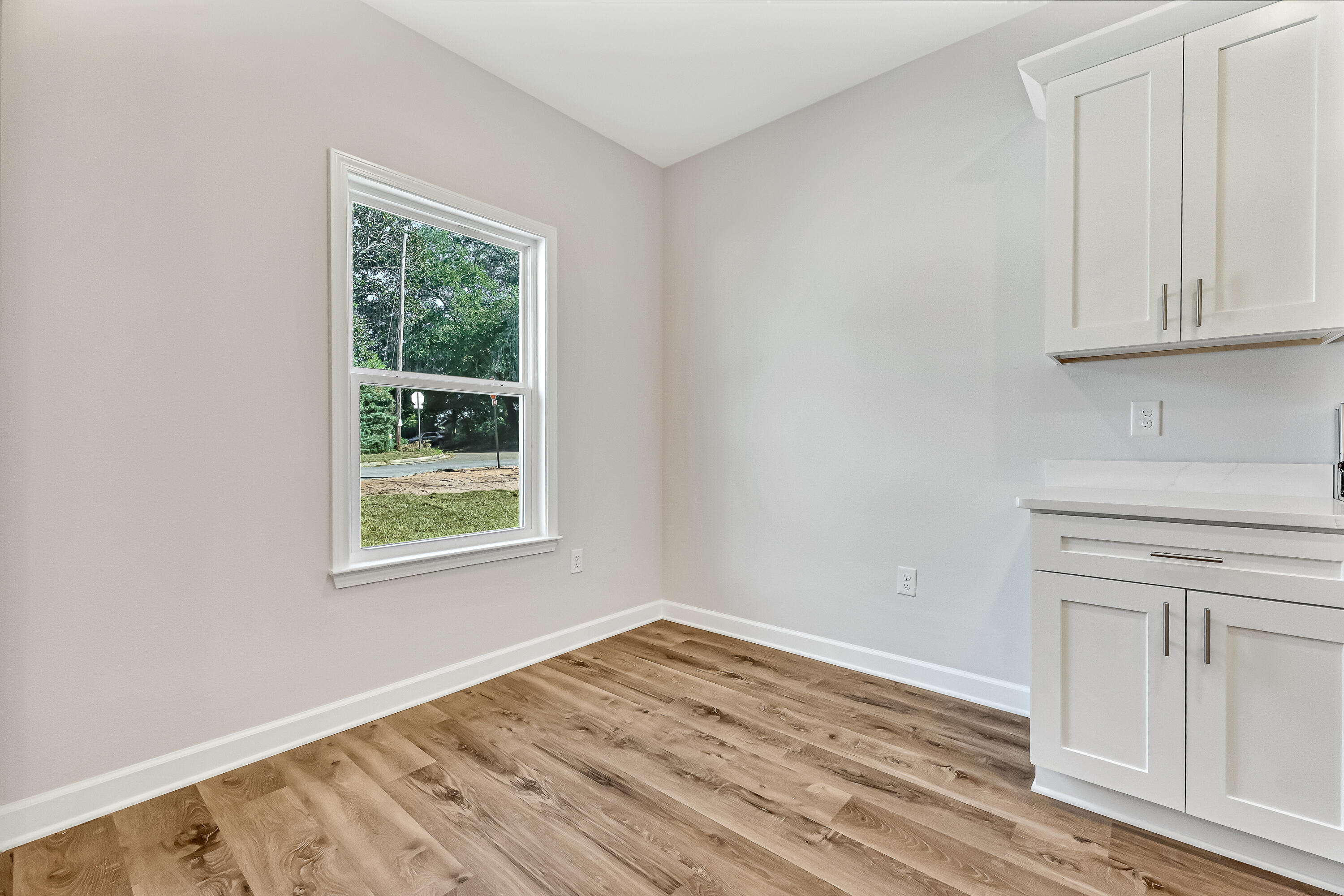 593 Brock Avenue Crestview, FL 32539 - Photo 10 of 19 an empty room with wooden floor and cabinet