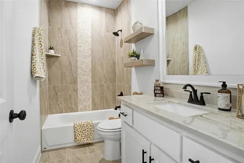 a bathroom with a granite countertop sink and a mirror a bathtub