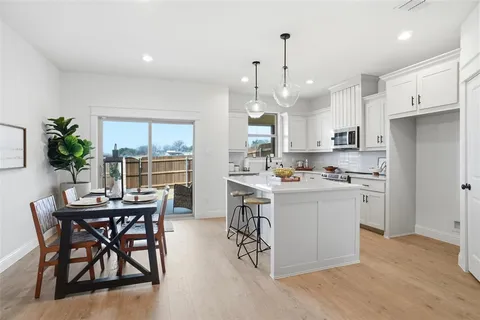 a kitchen with a table chairs refrigerator and microwave
