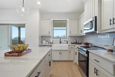 a kitchen with stainless steel appliances granite countertop a sink stove and cabinets
