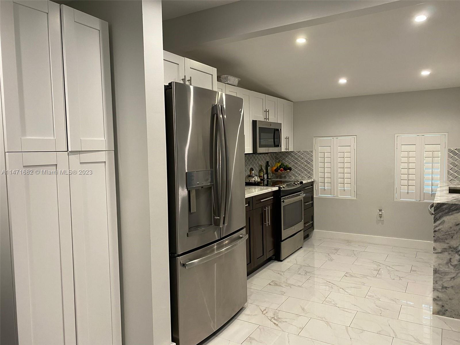 200 Southwest 30th Avenue Miami, FL 33135 - Photo 17 of 20 a kitchen with granite countertop a refrigerator and a sink