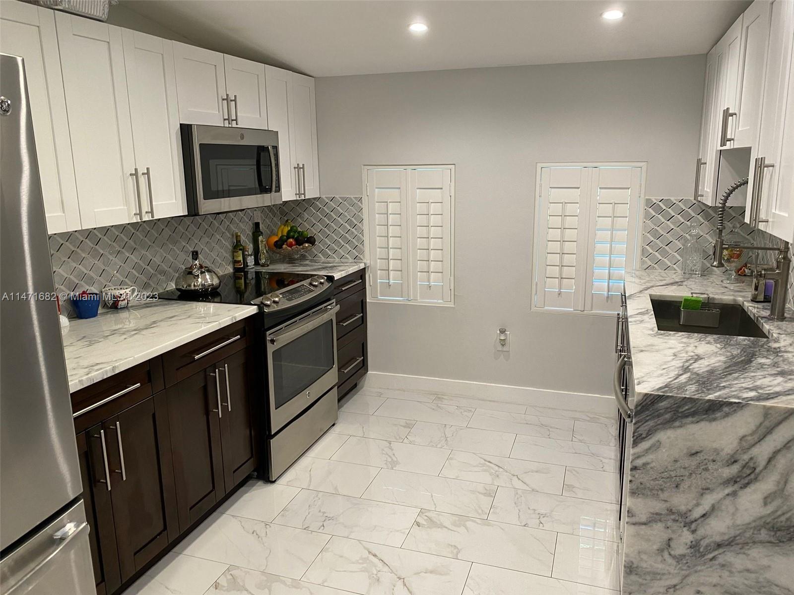 200 Southwest 30th Avenue Miami, FL 33135 - Photo 19 of 20 a kitchen with stainless steel appliances a stove sink microwave and cabinets