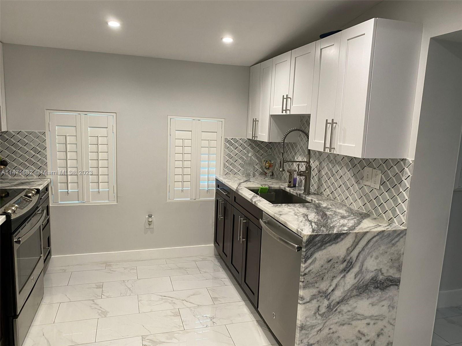 200 Southwest 30th Avenue Miami, FL 33135 - Photo 20 of 20 a kitchen with stainless steel appliances granite countertop a sink stove and refrigerator