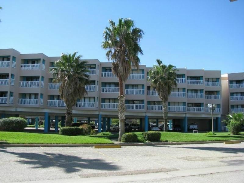 3938 Surfside Boulevard, Unit 3344 Corpus Christi, TX 78402 - Photo 2 of 34 a front view of multi story residential apartment building with yard and sign board