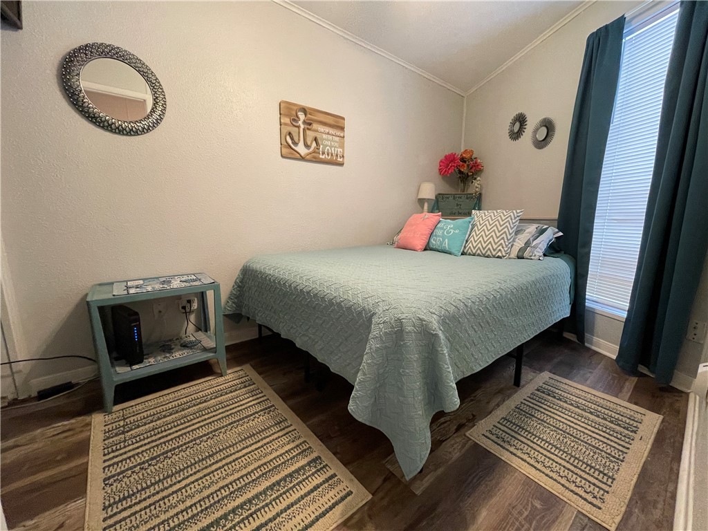 3938 Surfside Boulevard, Unit 3344 Corpus Christi, TX 78402 - Photo 21 of 34 a bedroom with a bed and wooden floor