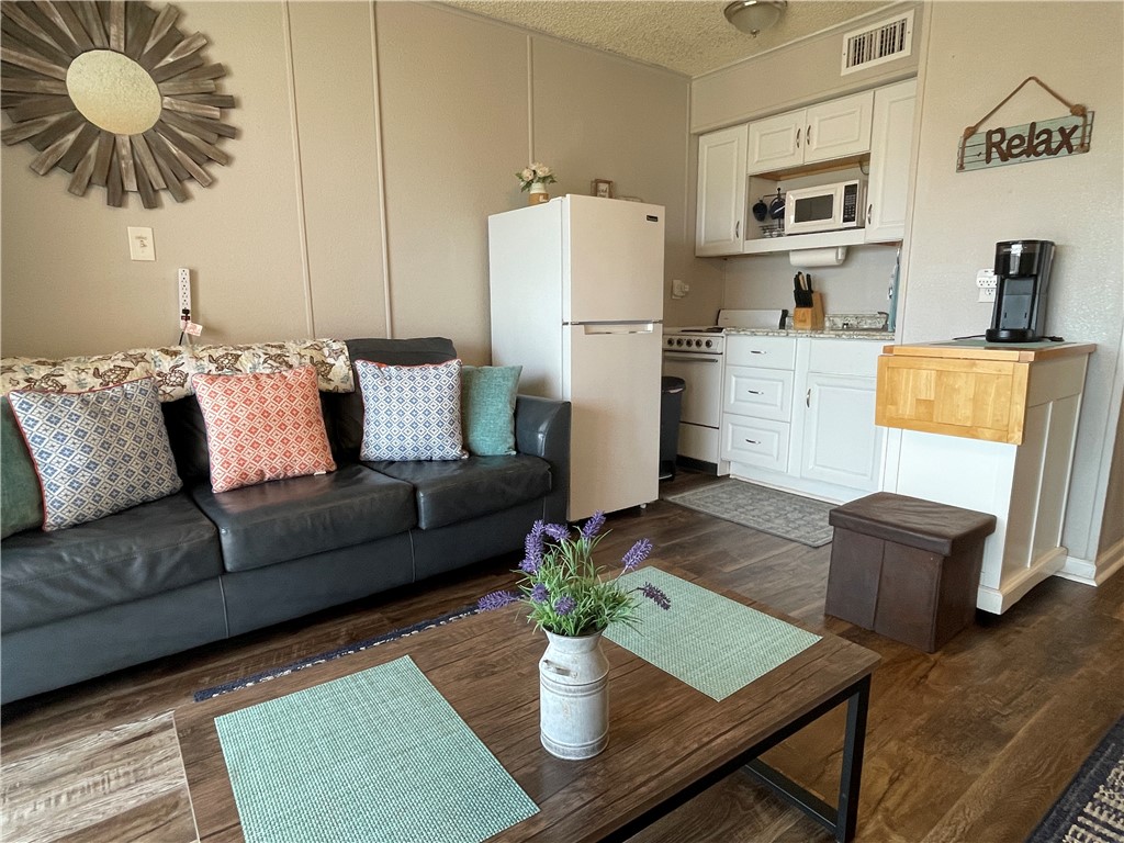 3938 Surfside Boulevard, Unit 3344 Corpus Christi, TX 78402 - Photo 3 of 34 a living room with furniture and a dining table with kitchen appliances