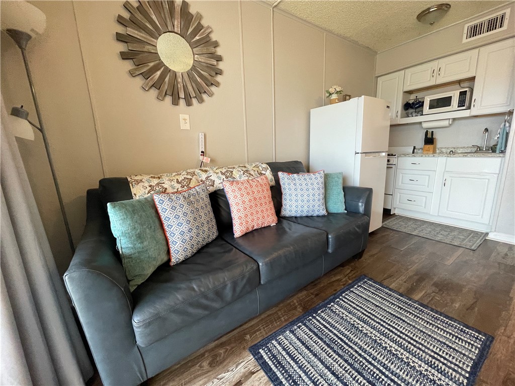3938 Surfside Boulevard, Unit 3344 Corpus Christi, TX 78402 - Photo 4 of 34 a living room with furniture and a kitchen view