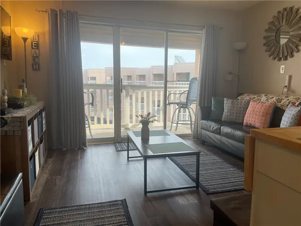 a living room with furniture and a floor to ceiling window