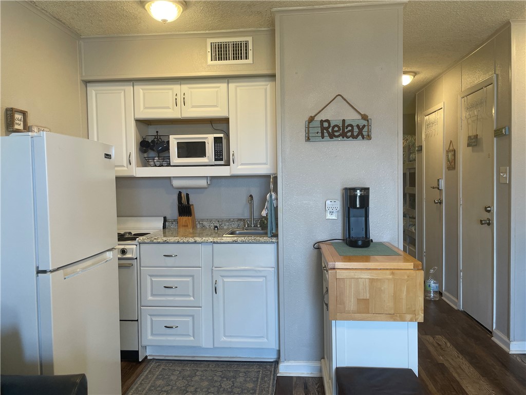 3938 Surfside Boulevard, Unit 3344 Corpus Christi, TX 78402 - Photo 9 of 34 a kitchen with stainless steel appliances a refrigerator and a stove top oven