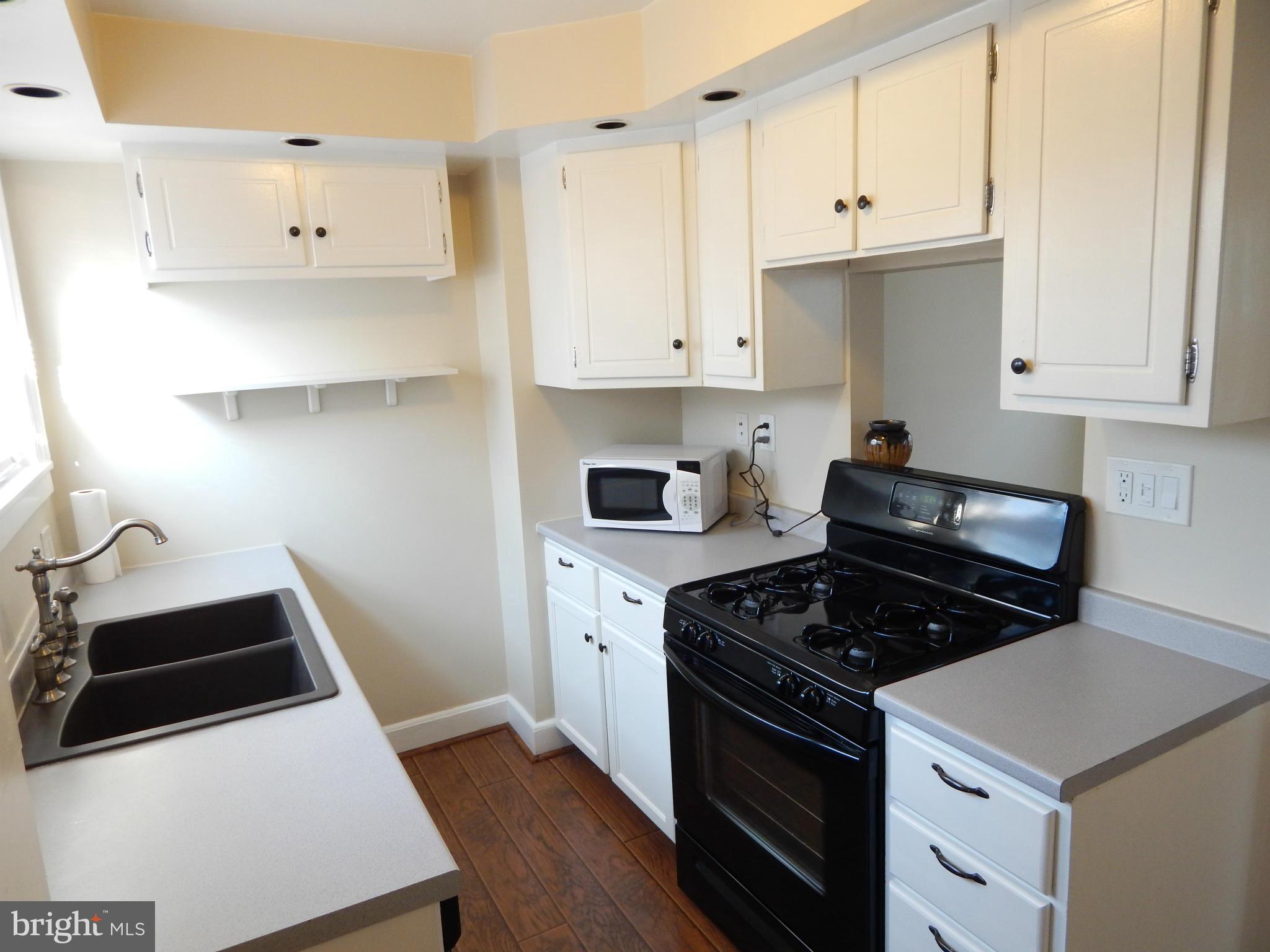25 Kinship Road Dundalk, MD 21222 - Photo 2 of 30 a kitchen with granite countertop white cabinets and stainless steel appliances