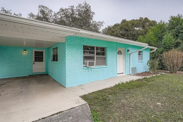 a view of a house with a backyard and trees