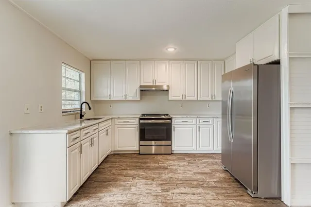 a kitchen with stainless steel appliances granite countertop a stove a refrigerator and a sink