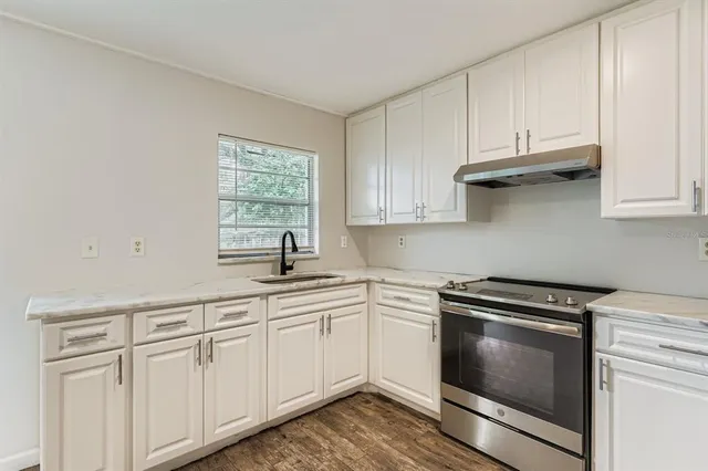 a kitchen with white cabinets and white appliances