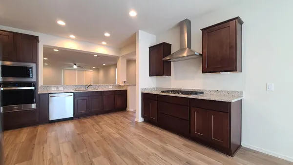 a large kitchen with stainless steel appliances granite countertop a stove a sink and a microwave