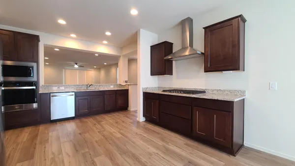 a large kitchen with stainless steel appliances granite countertop a stove a sink and a microwave