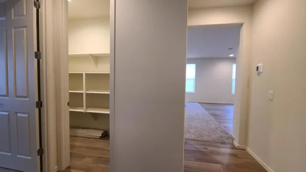 a view of a hallway with wooden floor and closet