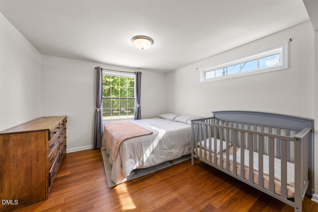 454 Cedar Creek Road Timberlake, NC 27583 - Photo 19 of 39 a bedroom with a bed and wooden floor