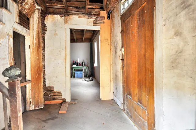 a view of a hallway with a livingroom and furniture