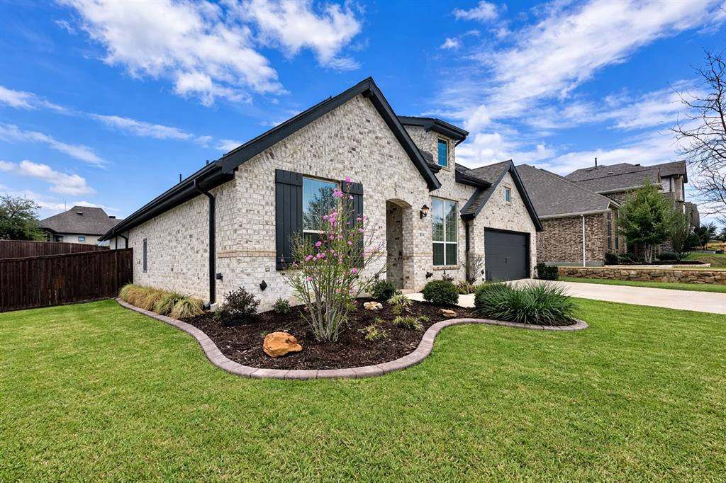 9820 Surveyor Road Little Elm, TX 75068 - Photo 1 of 40 French provincial home with a front yard, brick siding, and driveway