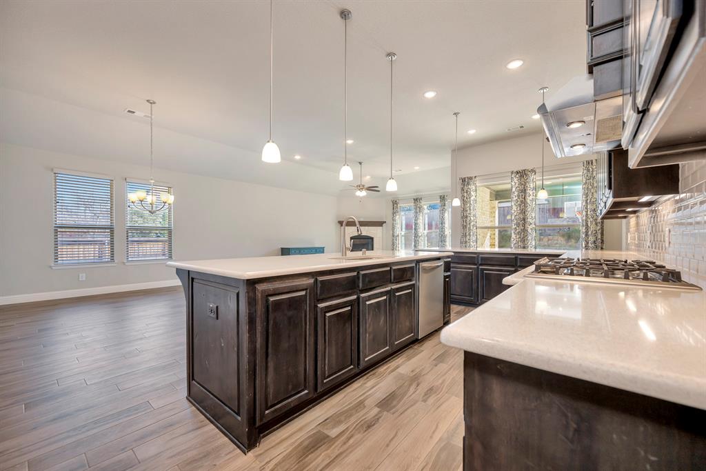 9820 Surveyor Road Little Elm, TX 75068 - Photo 40 of 40 Kitchen with tasteful backsplash, open floor plan, recessed lighting, dark brown cabinets, and a center island with sink