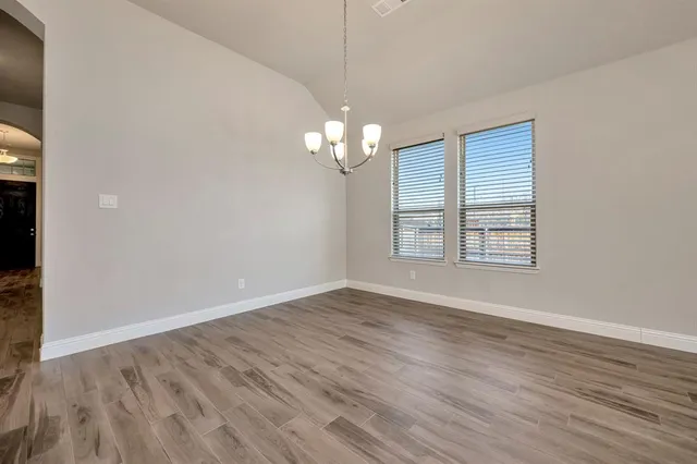 a kitchen with stainless steel appliances granite countertop wooden cabinets a refrigerator and a sink