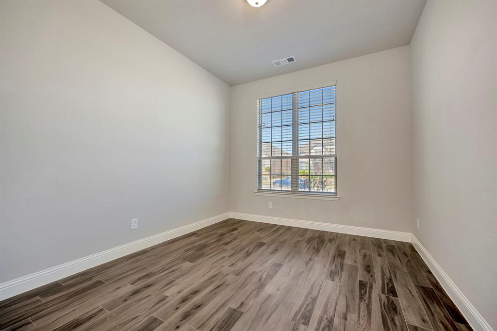 9820 Surveyor Road Little Elm, TX 75068 - Photo 13 of 40 Spare room featuring dark wood finished floors and baseboards
