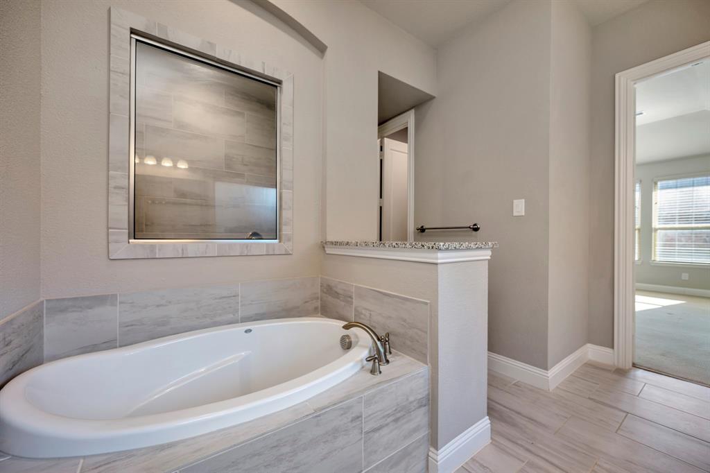 9820 Surveyor Road Little Elm, TX 75068 - Photo 18 of 40 Bathroom with a garden tub and baseboards
