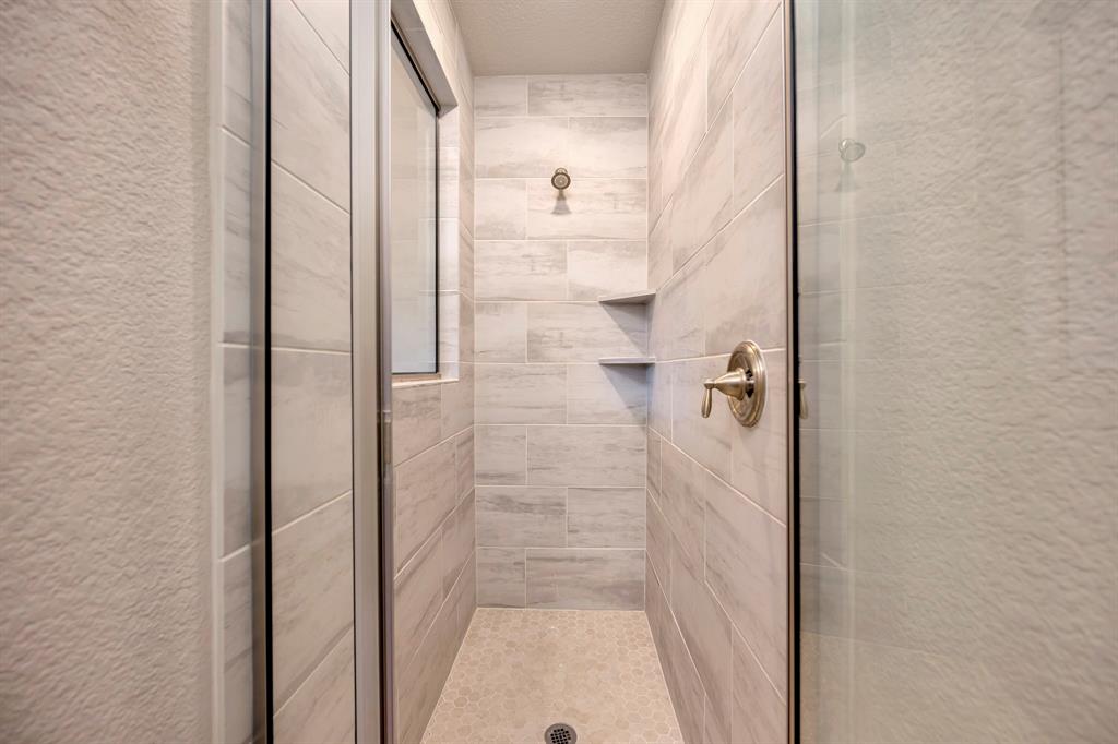 9820 Surveyor Road Little Elm, TX 75068 - Photo 19 of 40 Bathroom featuring a textured wall, a stall shower, and a textured ceiling