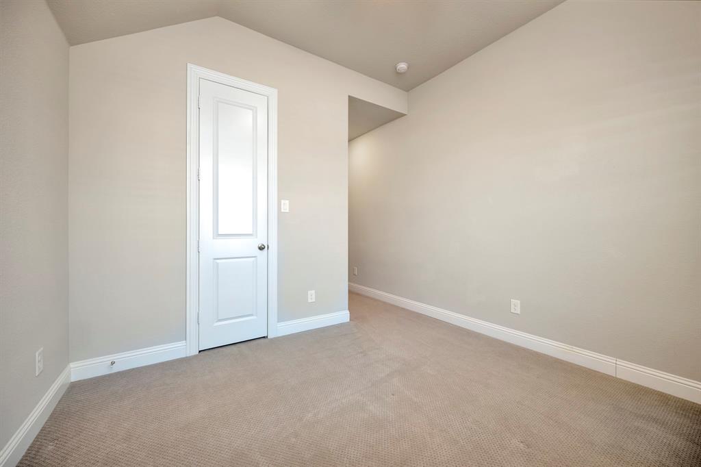 9820 Surveyor Road Little Elm, TX 75068 - Photo 22 of 40 Carpeted spare room featuring baseboards and vaulted ceiling