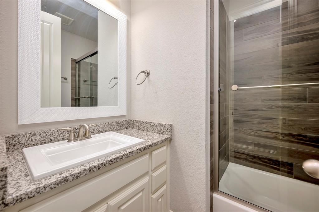9820 Surveyor Road Little Elm, TX 75068 - Photo 34 of 40 Bathroom featuring a textured wall, vanity, and enclosed tub / shower combo