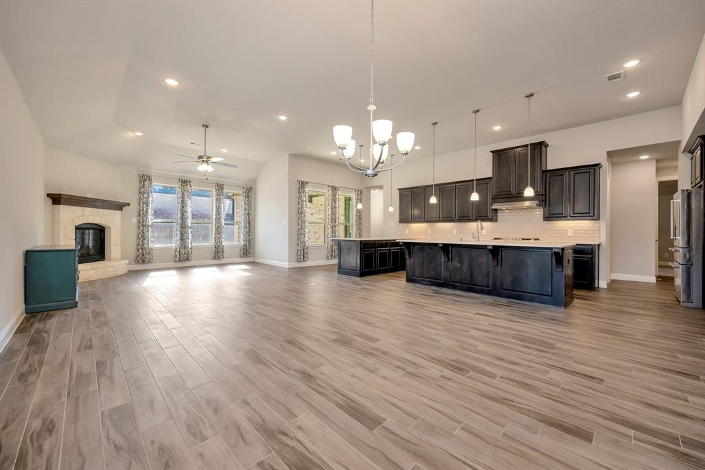9820 Surveyor Road Little Elm, TX 75068 - Photo 38 of 40 a large kitchen with a large counter top stainless steel appliances and wooden floor
