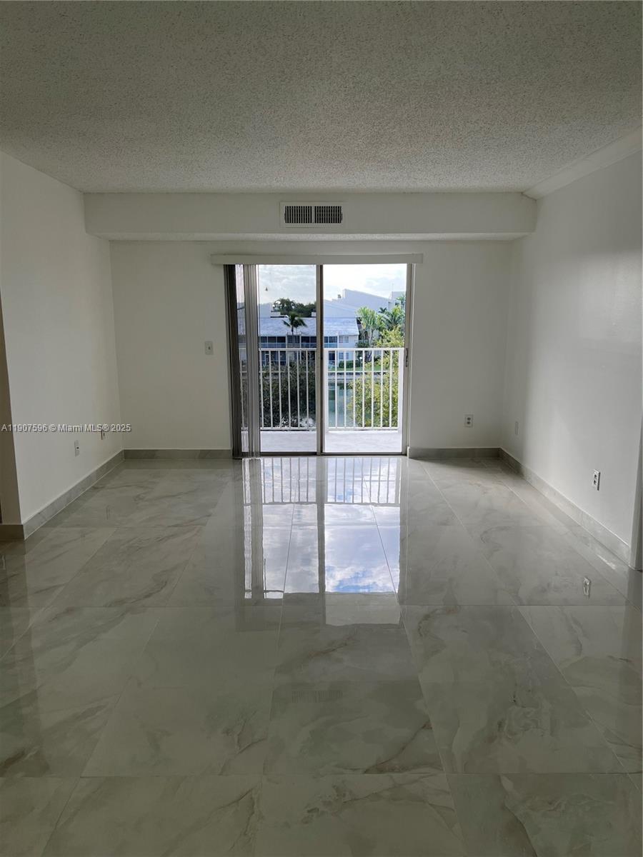 8260 Southwest 210th Street, Unit 302 Cutler Bay, FL 33189 - Photo 14 of 42 an empty room with floor to ceiling window and an entrance