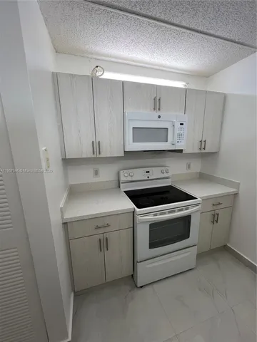 a kitchen with cabinets appliances and a sink