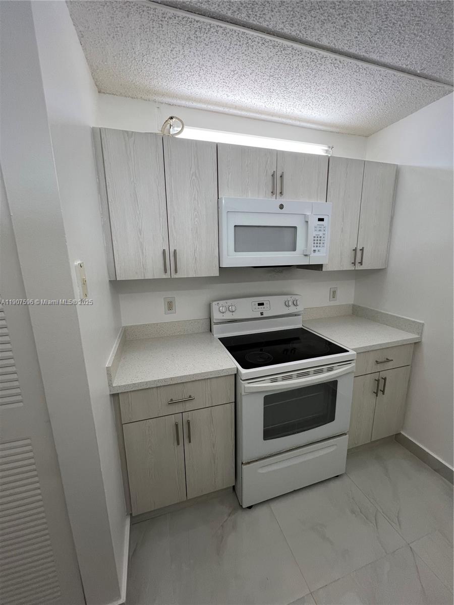 8260 Southwest 210th Street, Unit 302 Cutler Bay, FL 33189 - Photo 2 of 42 a kitchen with cabinets appliances and a sink