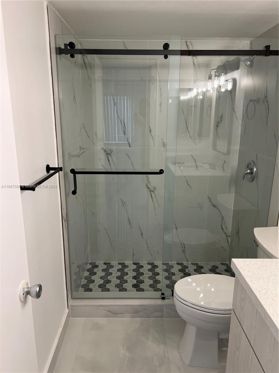 8260 Southwest 210th Street, Unit 302 Cutler Bay, FL 33189 - Photo 8 of 42 a bathroom with a shower a toilet and a shower