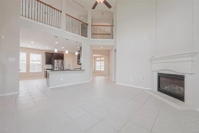 a view of an empty room and a kitchen