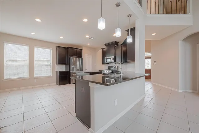 a large kitchen with stainless steel appliances kitchen island granite countertop a sink and cabinets