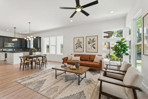 a living room with furniture kitchen view and a potted plant